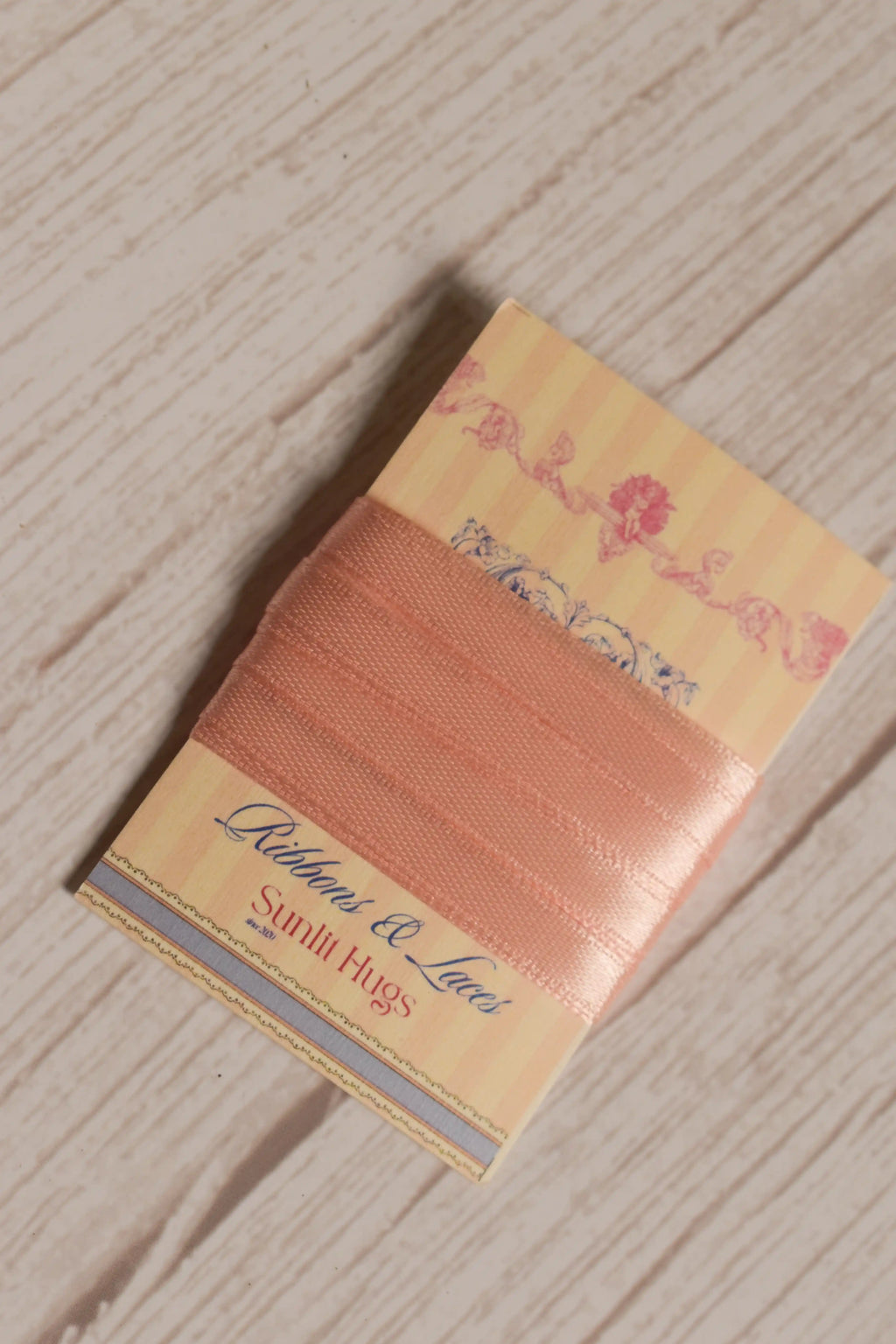 A 2 meter Apricot Satin Ribbon displayed on a decorative Sunlit Hugs card, suitable for gift wrapping, craft projects, packaging, and bows.