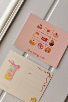 This side-by-side view displays the complete Birthday Bakes Postcard design, showing the dessert grid next to the elegant macaron tower on the address side.