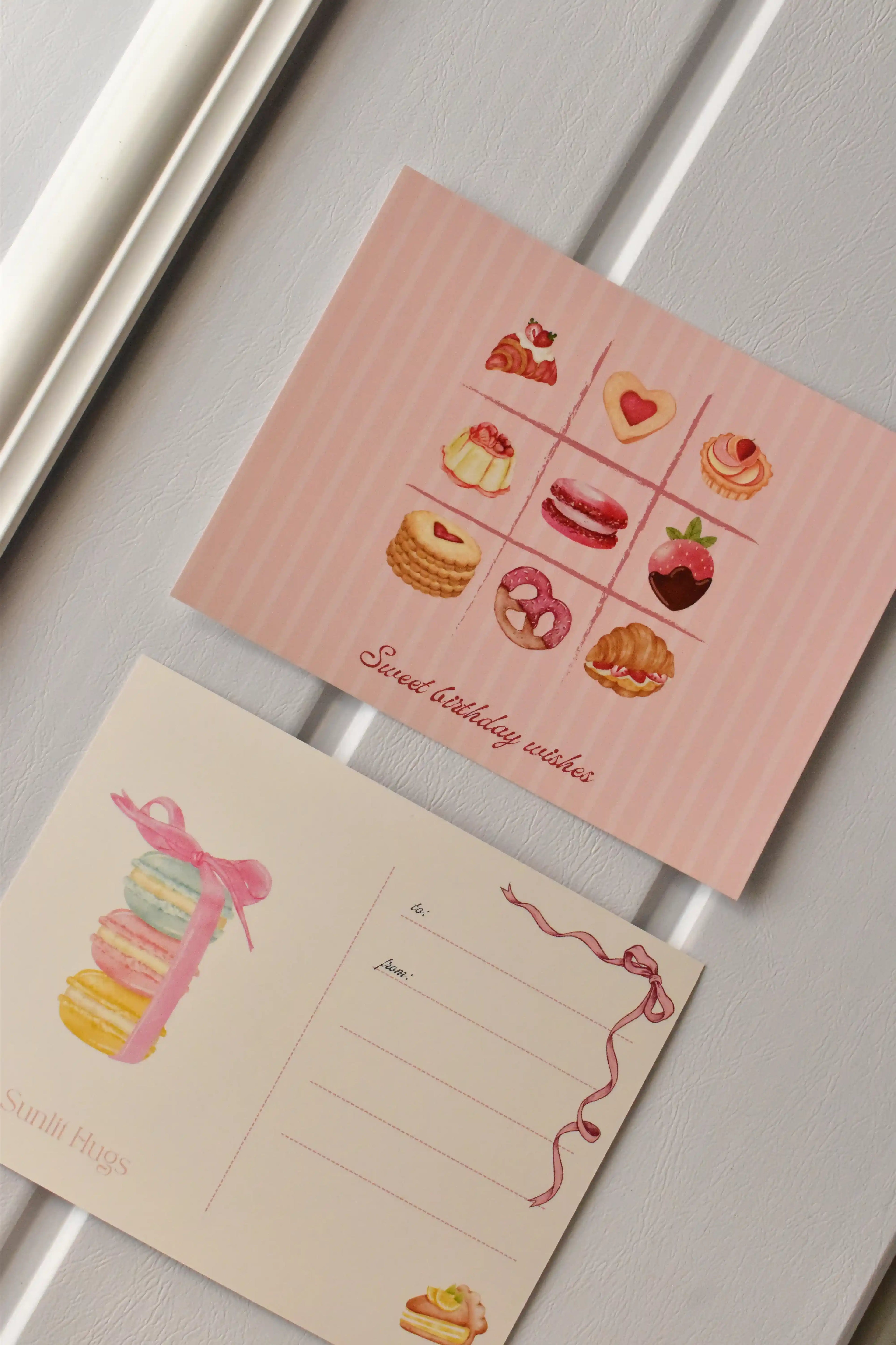 This side-by-side view displays the complete Birthday Bakes Postcard design, showing the dessert grid next to the elegant macaron tower on the address side.