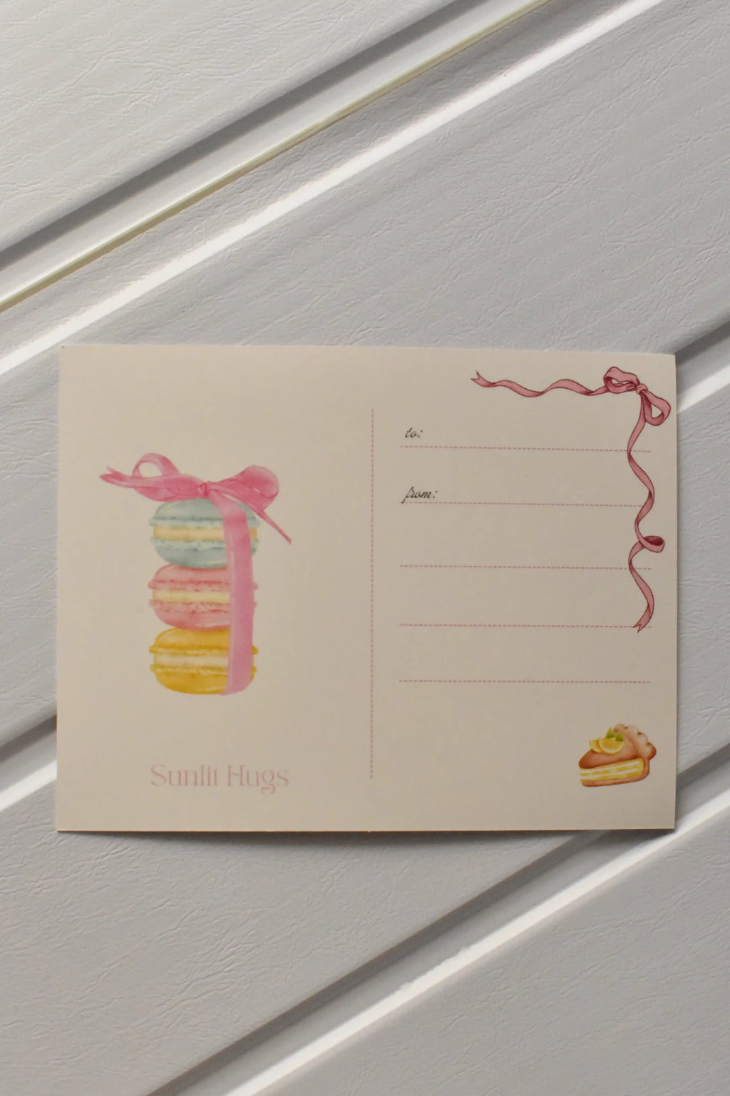 This image focuses on the reverse of the postcard, highlighting the beautiful macaron stack illustration that adds a sweet touch before the postcard is sent to a loved one.