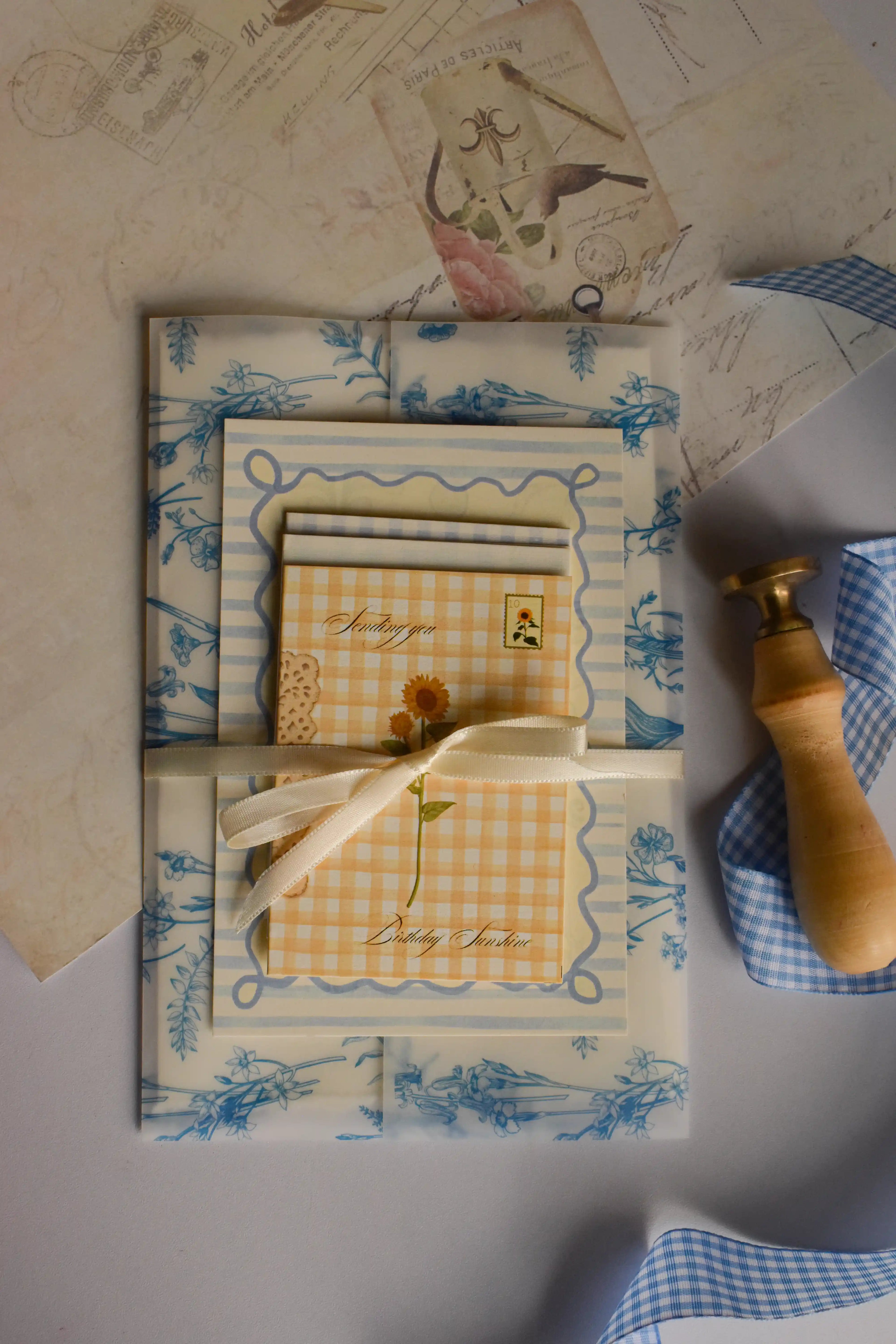 The complete birthday stationery collection displayed with blue botanical wrapping paper, sunflower-themed card, vintage details, and elegant gift presentation.