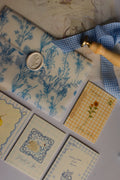 The complete birthday stationery collection displayed with blue botanical wrapping paper, sunflower-themed card, vintage details, and elegant gift presentation.