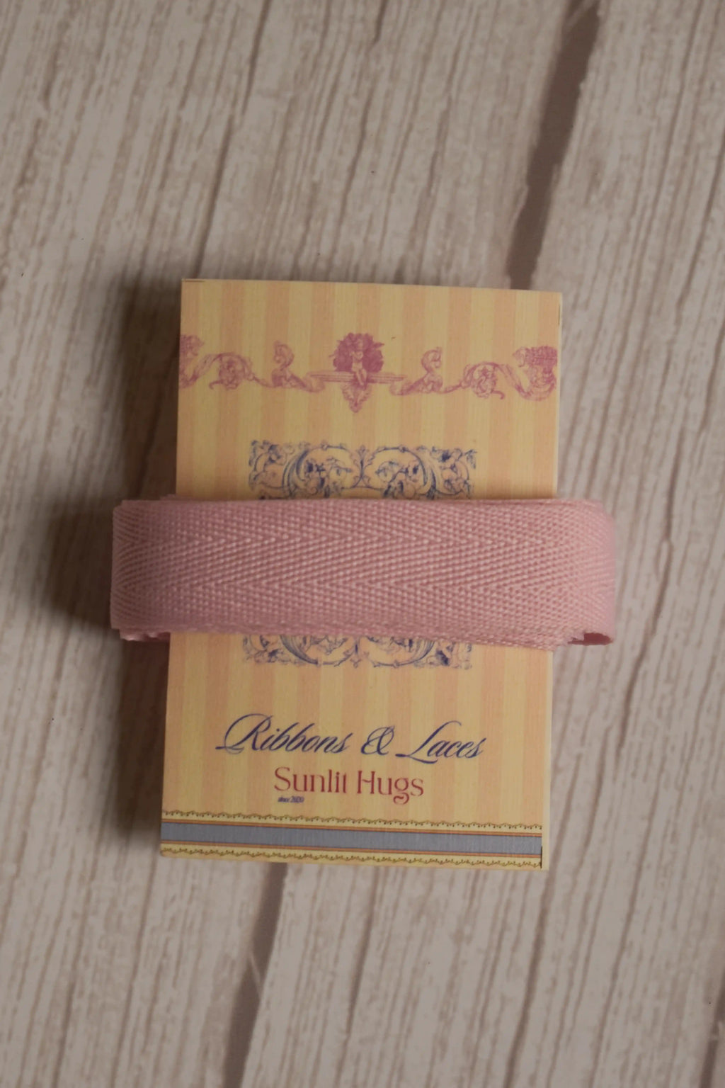 Blush pink grain ribbon wrapped around a printed Sunlit Hugs ribbon card, showing its soft colour and textured finish for gift wrapping and crafts.