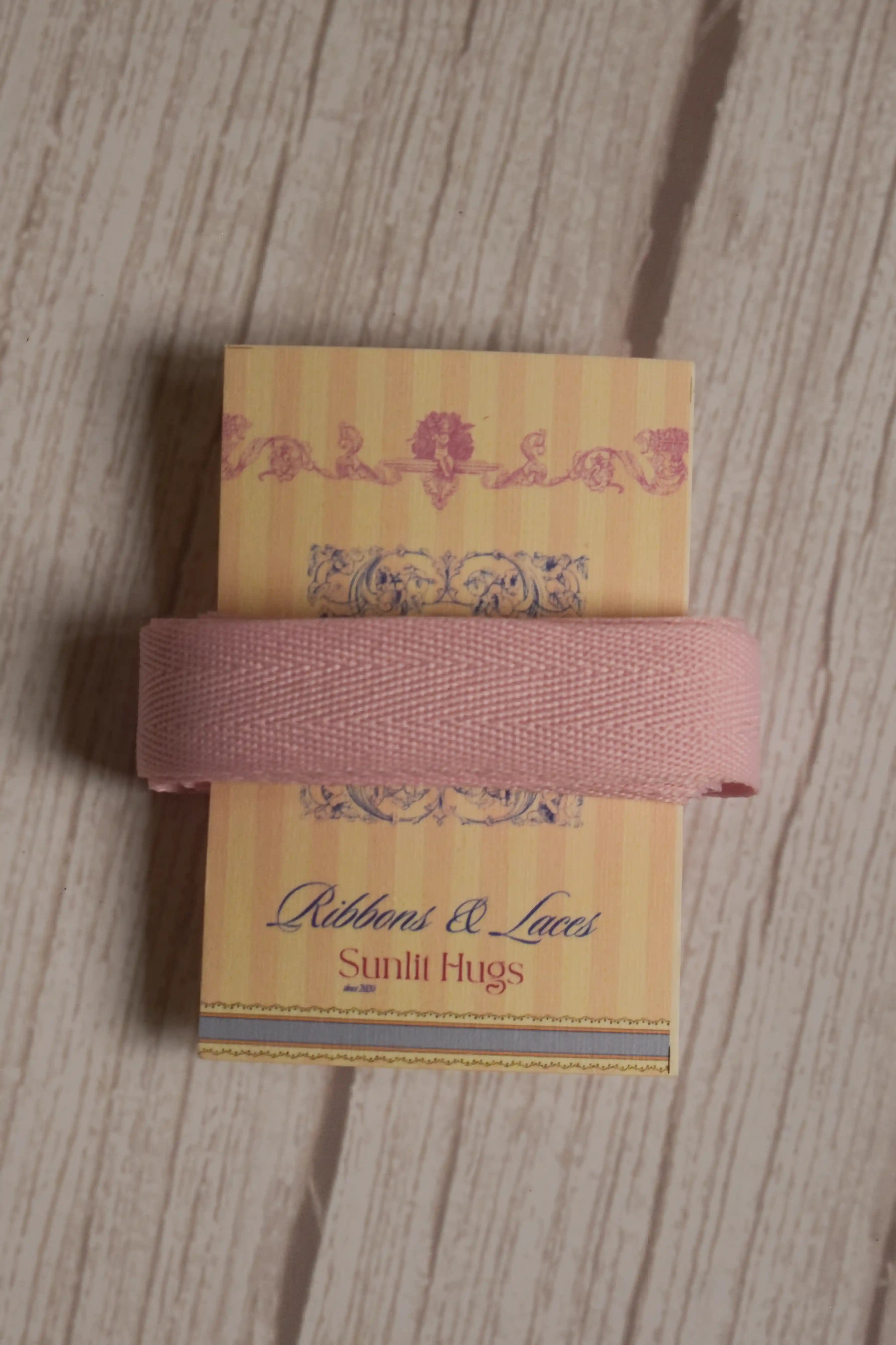 Blush pink grain ribbon wrapped around a printed Sunlit Hugs ribbon card, showing its soft colour and textured finish for gift wrapping and crafts.
