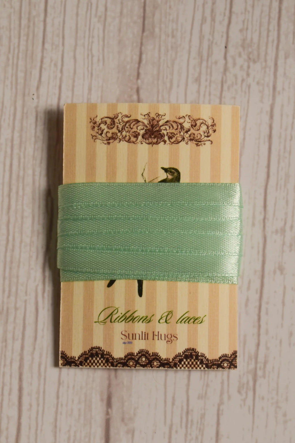 Mint Breeze Ribbon wrapped around a printed Sunlit Hugs ribbon card, showing its soft green colour and narrow 6 mm width.