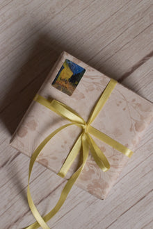 A gift parcel wrapped with Butter Cream Satin Ribbon, showing the soft pale yellow satin ribbon tied into a delicate bow for elegant packaging.