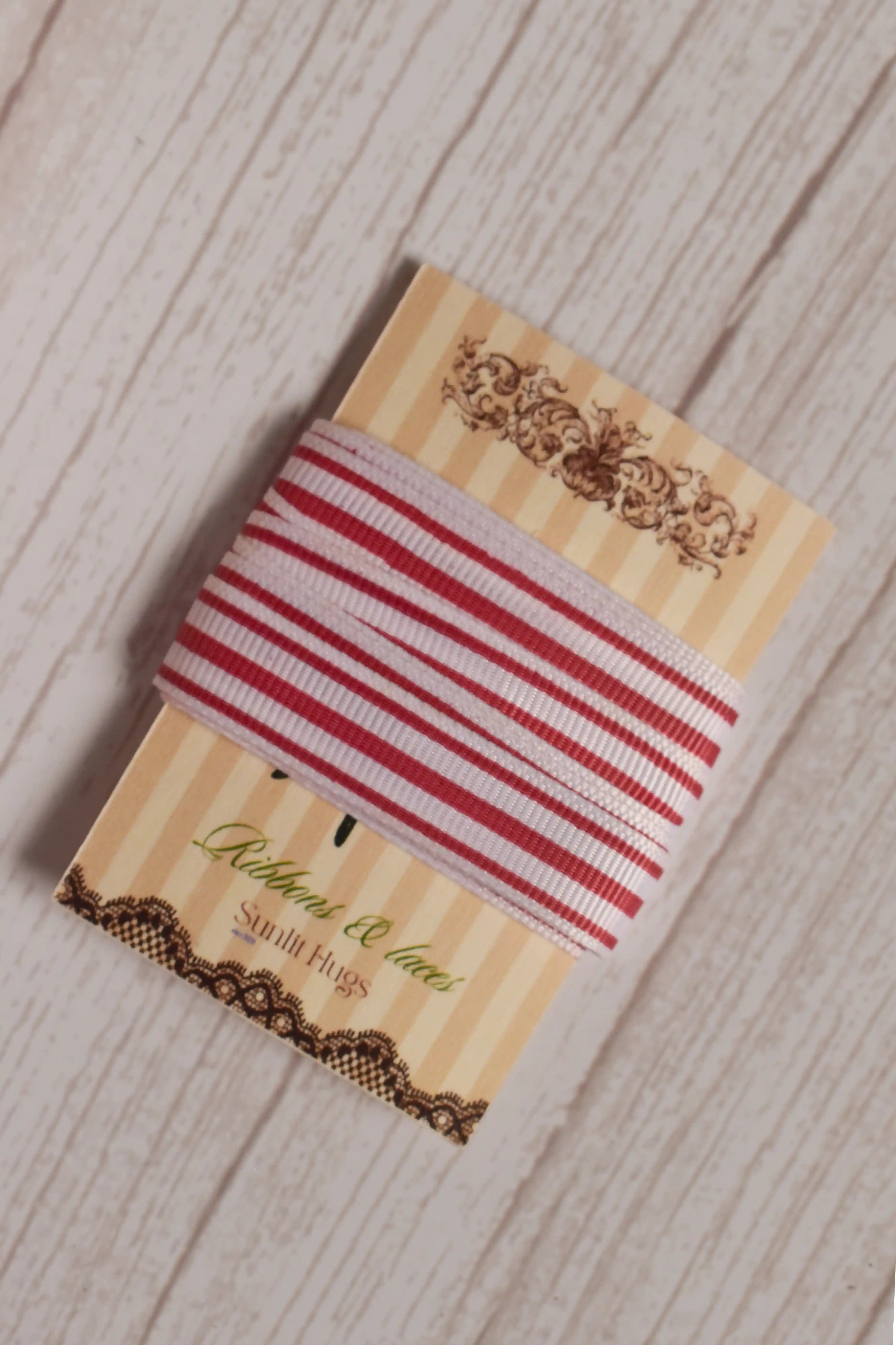 Close-up of Cheese Tomato Stripes Ribbon displayed on a Sunlit Hugs ribbon card, showing its light base and tomato red striped design.