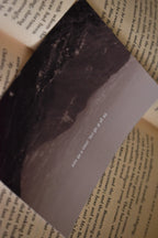 Macro detail shot of the 'Ek Tum Hi Nahi Tanha' Landour Photo Print resting on a book page, focusing on the dark mountain valleys and the poetic Hindi lyric text.
