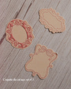 Three decorative die-cut tags on a wooden surface with 'Coquette die cut tags: set of 3' text.