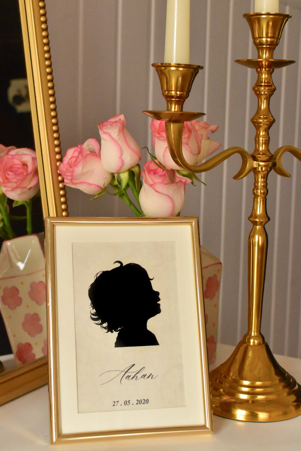 A warm, close-up view of the custom child silhouette, highlighting the intricate profile and the golden frame. The name and date celebrate a treasured milestone in a timeless style.
