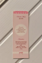 This image focuses on the practical element, displaying the detailed Chocolate Mousse Recipe printed on the back of the pastel pink bookmark.