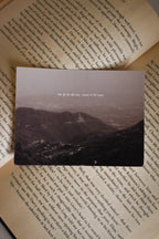 ront view of the 'Ek Tum Hi Nahi Tanha' Landour Photo Print by Anneshwa Paul displayed on the text-filled pages of a classic novel, capturing the dark academia aesthetic of atmospheric Himalayan mountains.