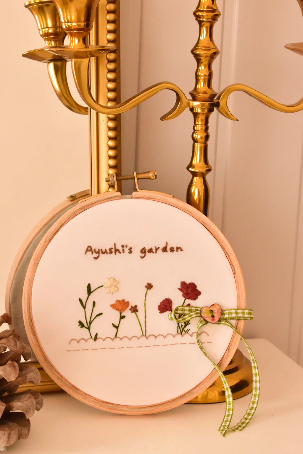 Custom hand embroidered hoop displayed next to an ornate golden candelabra, highlighting the vintage, cosy home decor aesthetic.