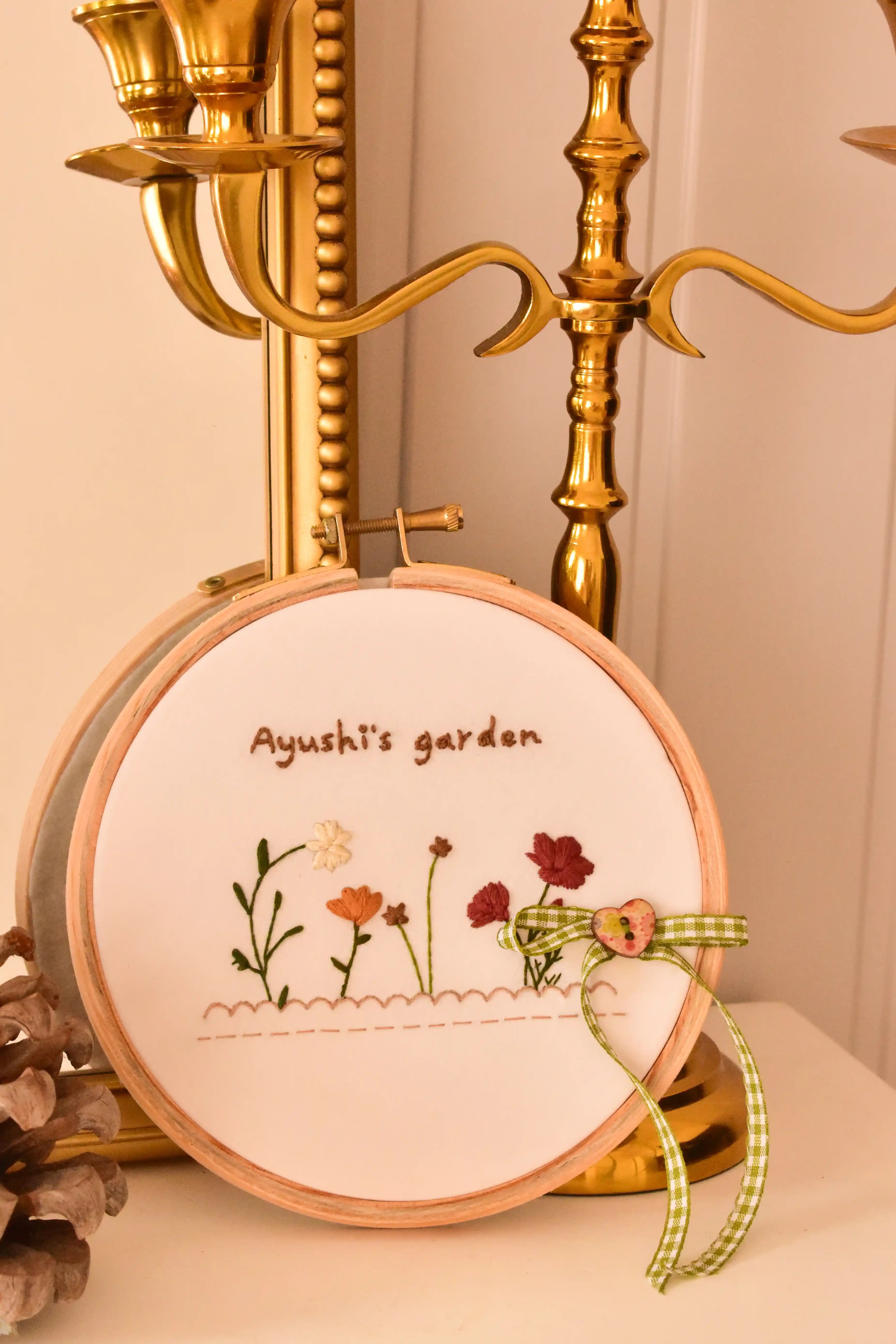 Custom hand embroidered hoop displayed next to an ornate golden candelabra, highlighting the vintage, cosy home decor aesthetic.