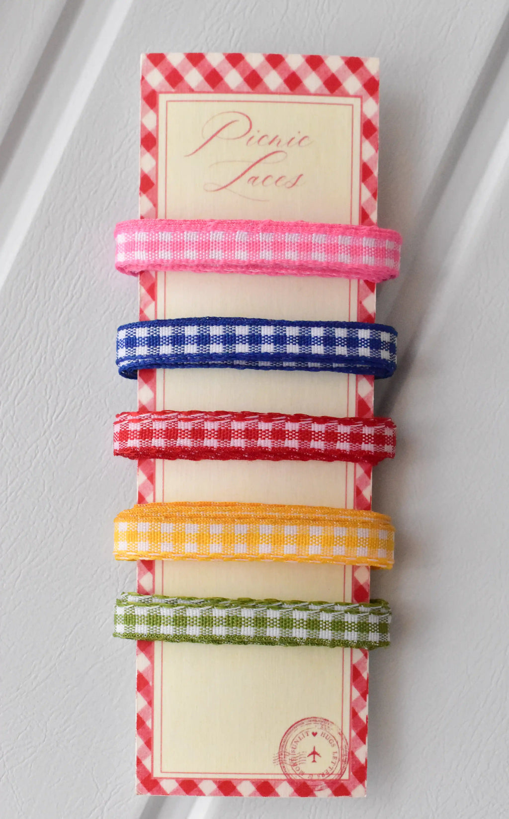 Five narrow gingham ribbons in pink, blue, red, yellow, and green, displayed vertically on a themed ribbon card.