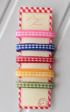 Five narrow gingham ribbons in pink, blue, red, yellow, and green, displayed vertically on a themed ribbon card.