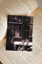 Front view of the 'The Sacred Window' Landour Photo Print on a text-filled book page, capturing the quiet, vintage cottagecore charm of a sunlit mountain window sill.