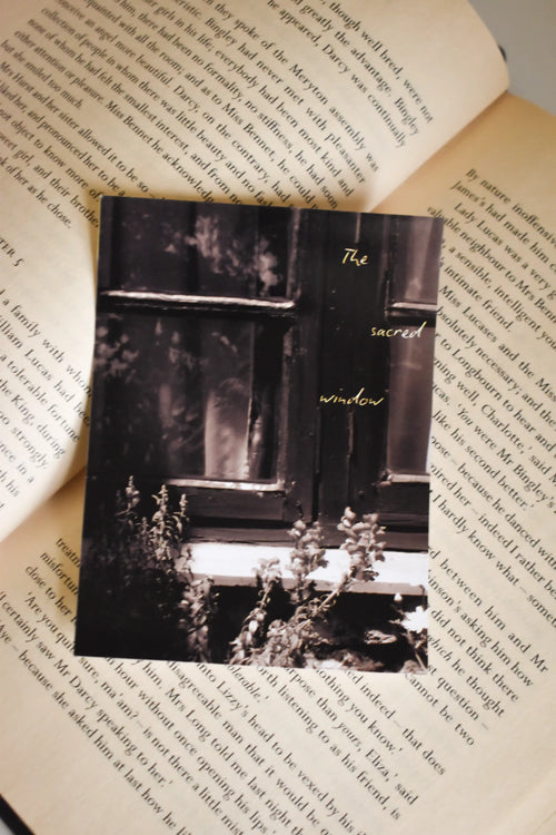Front view of the 'The Sacred Window' Landour Photo Print on a text-filled book page, capturing the quiet, vintage cottagecore charm of a sunlit mountain window sill.