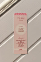 This image focuses on the practical element, displaying the detailed Fruit Parfait Recipe printed on the back of the pastel pink bookmark, ready for your kitchen inspiration.