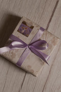 A vintage-style gift parcel tied with Lavender Song Ribbon, showing the soft lavender purple ribbon styled as a decorative bow for thoughtful packaging.