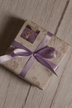 A vintage-style gift parcel tied with Lavender Song Ribbon, showing the soft lavender purple ribbon styled as a decorative bow for thoughtful packaging.