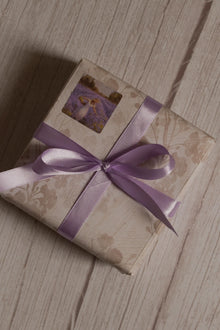 A vintage-style gift parcel tied with Lavender Song Ribbon, showing the soft lavender purple ribbon styled as a decorative bow for thoughtful packaging.