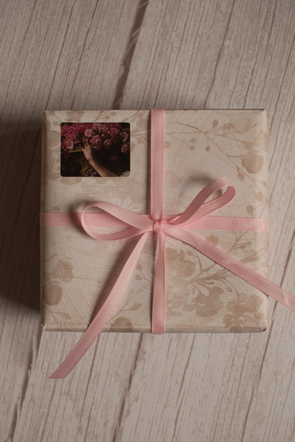 A vintage-style gift parcel tied with Petal Silk Ribbon, showing the soft pink ribbon styled as a delicate bow for thoughtful packaging.