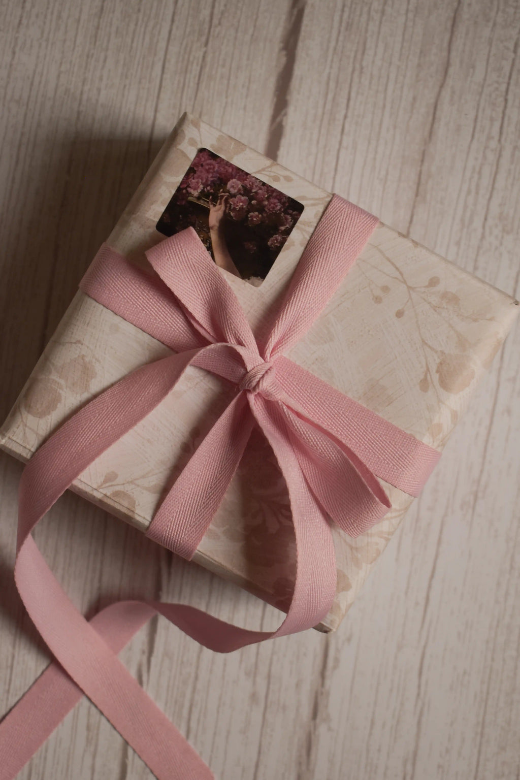 A vintage-style gift parcel tied with a blush pink grain ribbon bow, showing how the ribbon can be used for soft and elegant gift packaging.