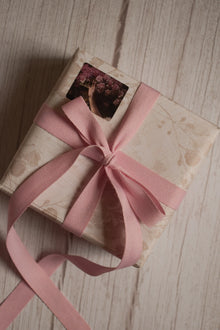 A vintage-style gift parcel tied with a blush pink grain ribbon bow, showing how the ribbon can be used for soft and elegant gift packaging.