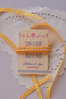 Mango Gingham Checkered Ribbon displayed on a Sunlit Hugs ribbon card, showing its mango yellow and white checkered design with loose ribbon styling for crafts, packaging, and bows.