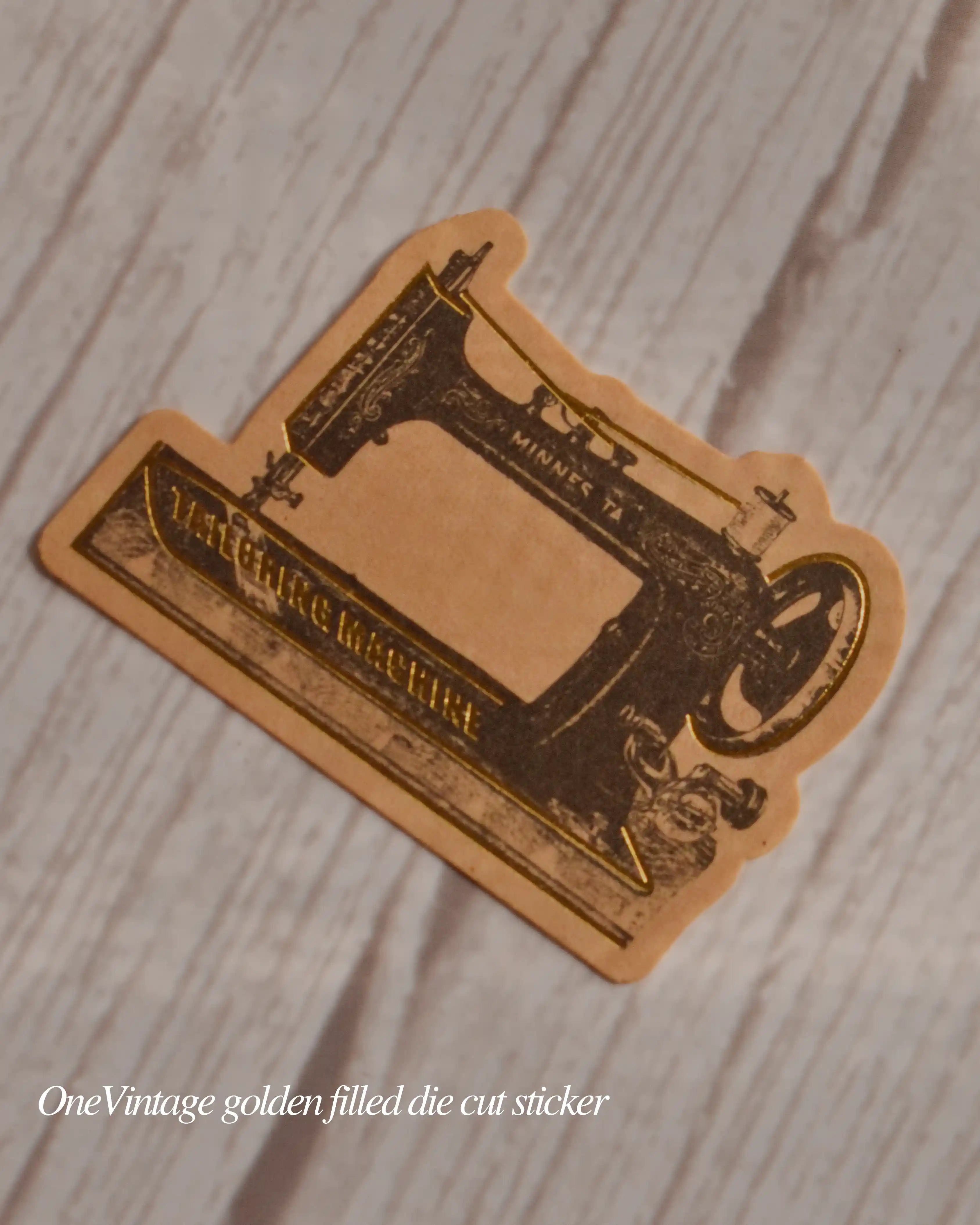 Vintage-style sewing machine die-cut sticker on a wooden surface