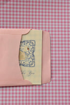 This view captures the beginning of the card's journey, showing the Grateful For You card, with its beautiful blue design, being placed into the pink envelope, ready to be sent as a warm gesture of thanks.