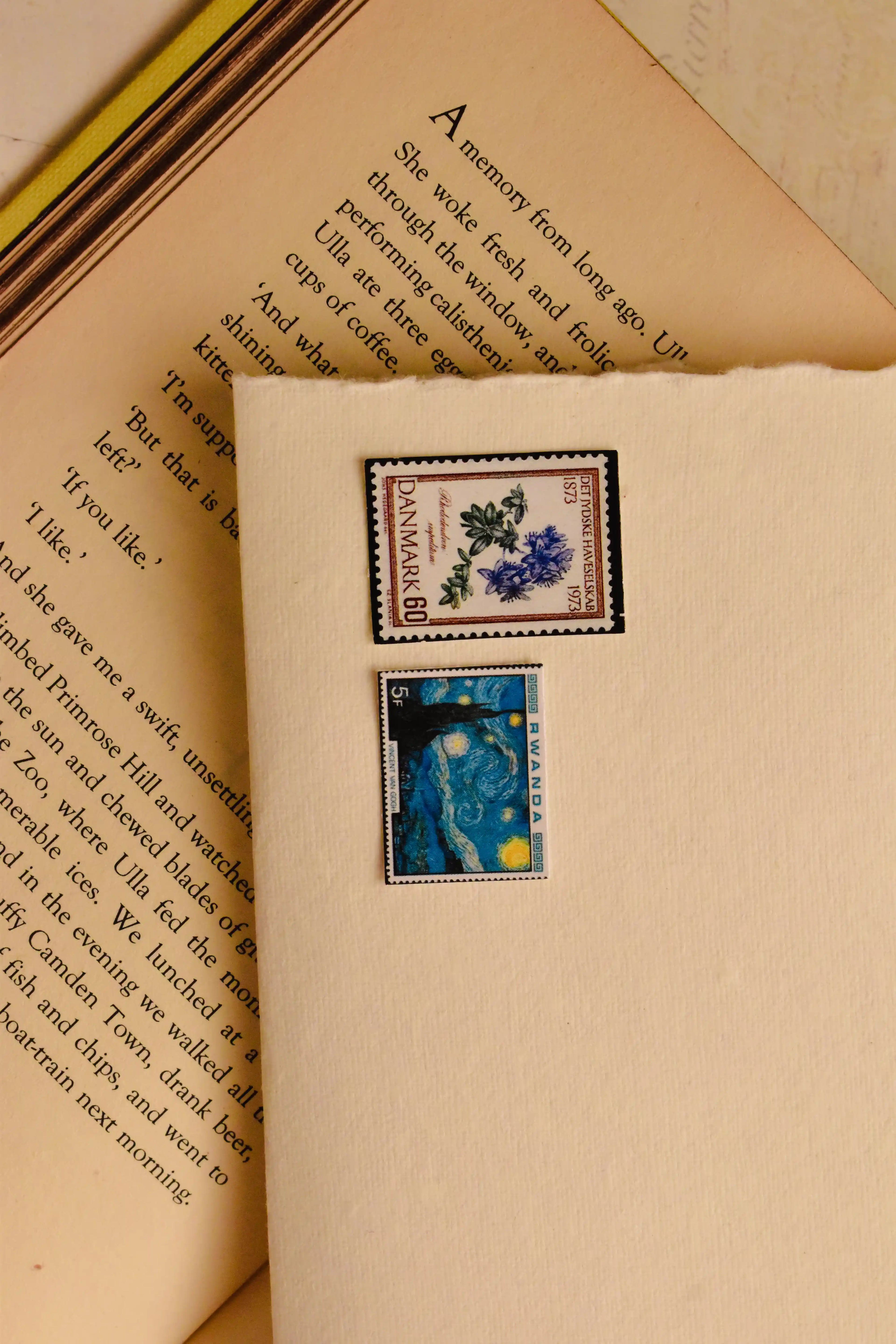 This image shows a lovely detail of the handmade ivory paper, decorated with vintage-style postage stamps, adding a final touch of nostalgic charm to the presentation.