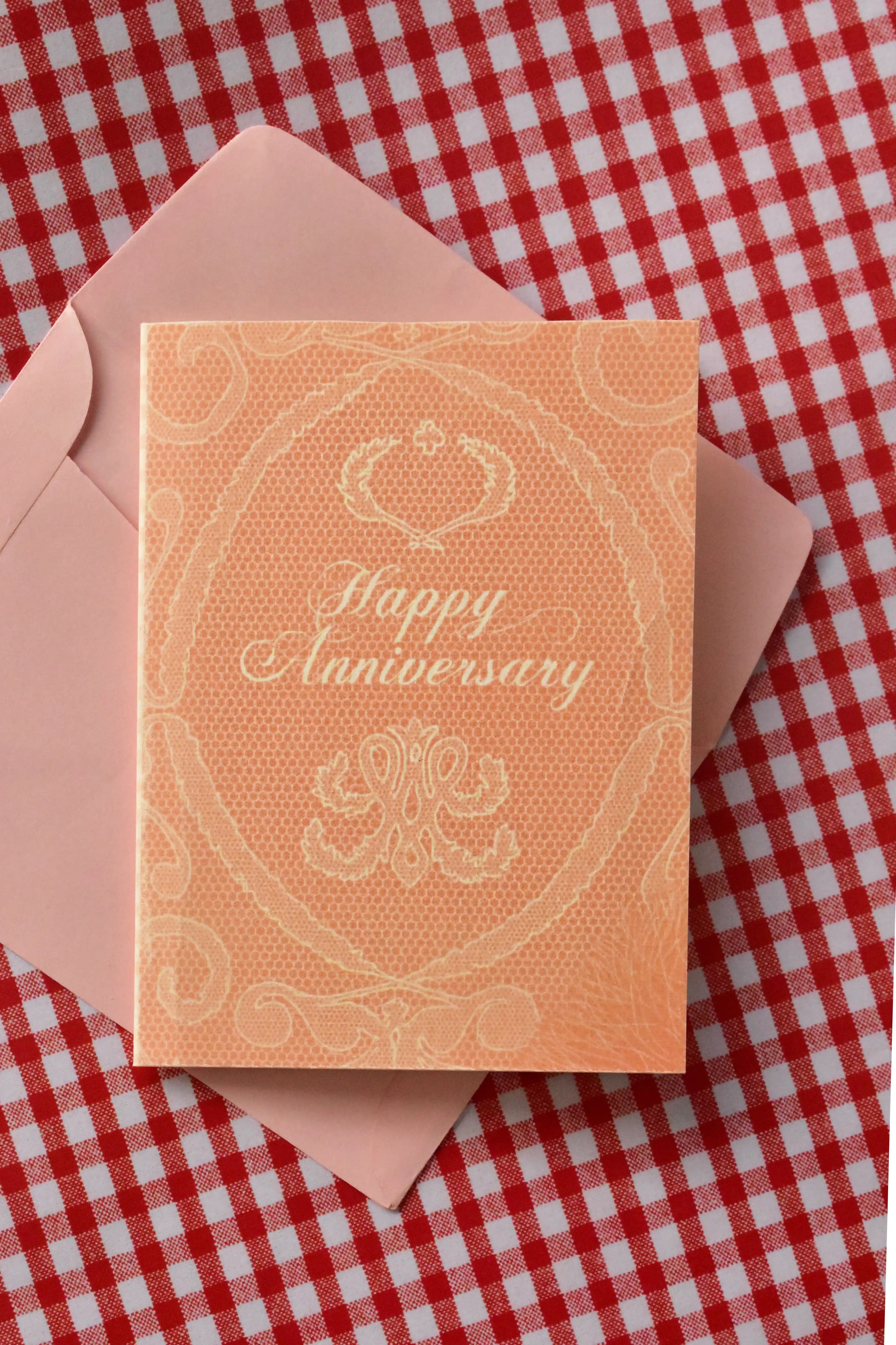 This image focuses on the elegant Happy Anniversary card, emphasizing the sophisticated peach tone and white lace design that celebrates a beautiful, treasured romance.