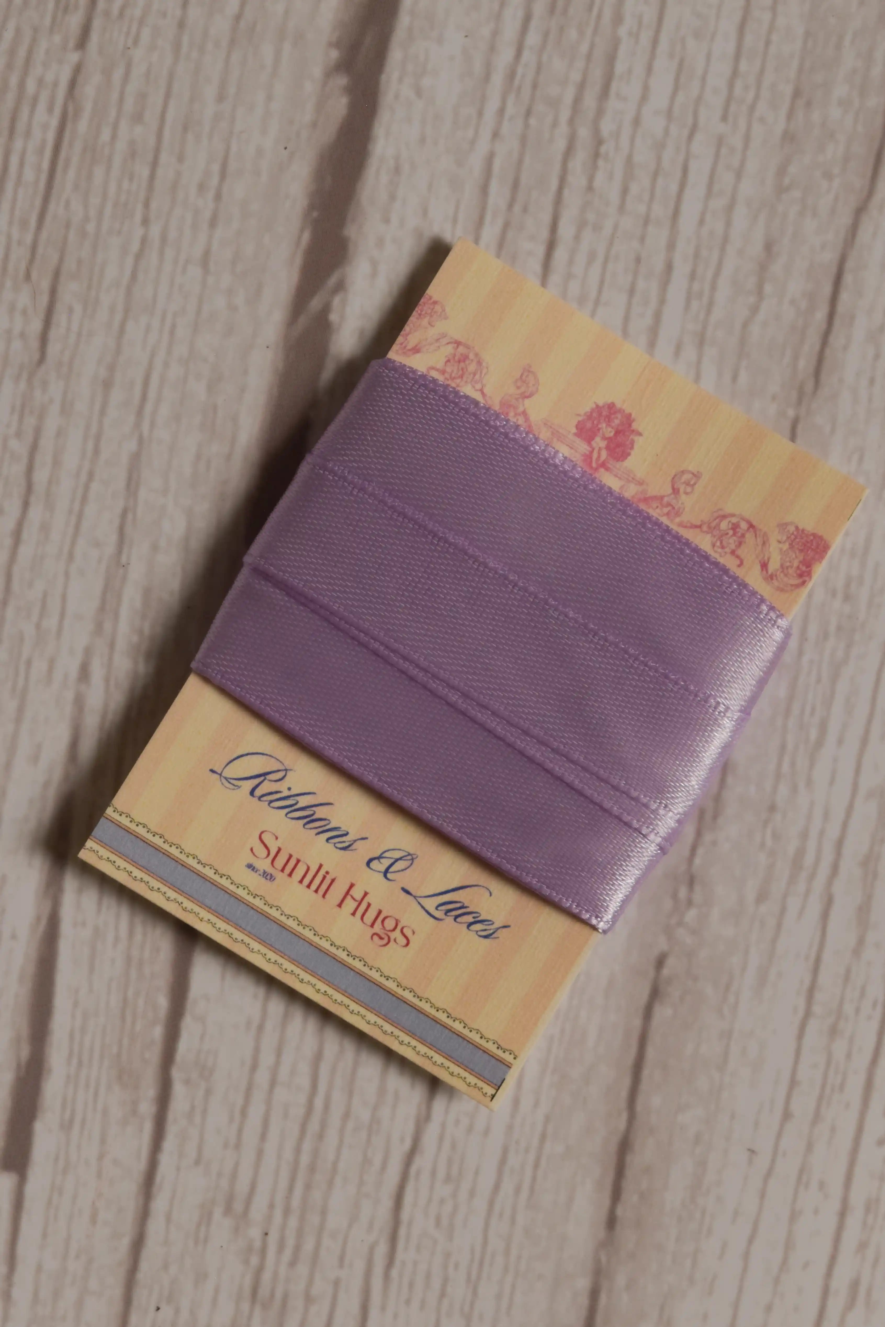 Lavender Song Ribbon wrapped around a printed Sunlit Hugs ribbon card, showing its 13 mm width and soft purple shade for crafts, packaging, and bows.