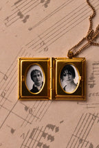 This angled image captures the open golden alloy locket, demonstrating how beautifully the black and white photos sit within the vintage frames. (Note: Chain is for visual purposes only).