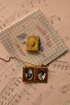 The golden alloy locket is displayed on the Sunlit Hugs branded card, highlighting its intricate vintage design and rich golden colour for a charming presentation.