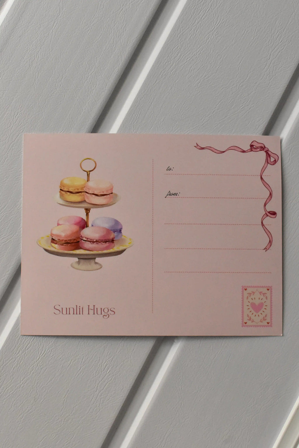 This image shows the reverse side of the postcard, where a tier of colourful macarons and the address lines are featured, ready for your handwritten message and stamp.