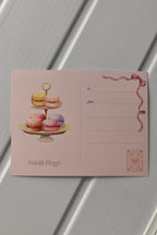 This image shows the reverse side of the postcard, where a tier of colourful macarons and the address lines are featured, ready for your handwritten message and stamp.