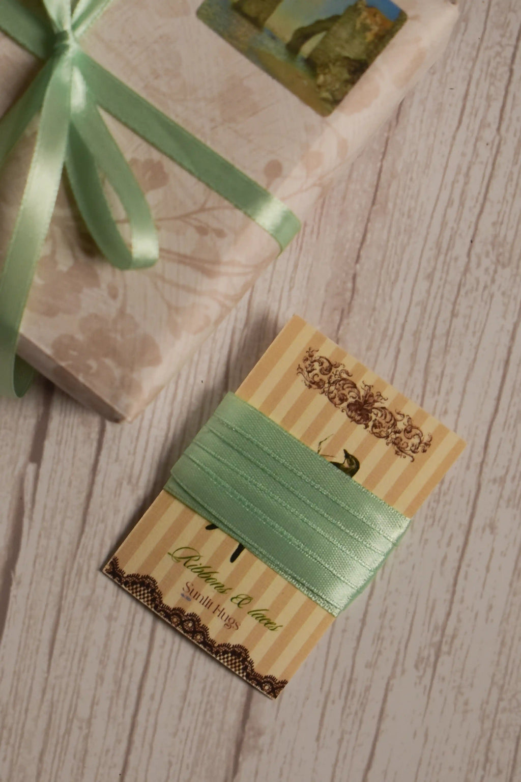 Mint Breeze Ribbon shown on a Sunlit Hugs ribbon card beside a wrapped gift, highlighting its soft mint green shade for packaging, crafts, and bows.