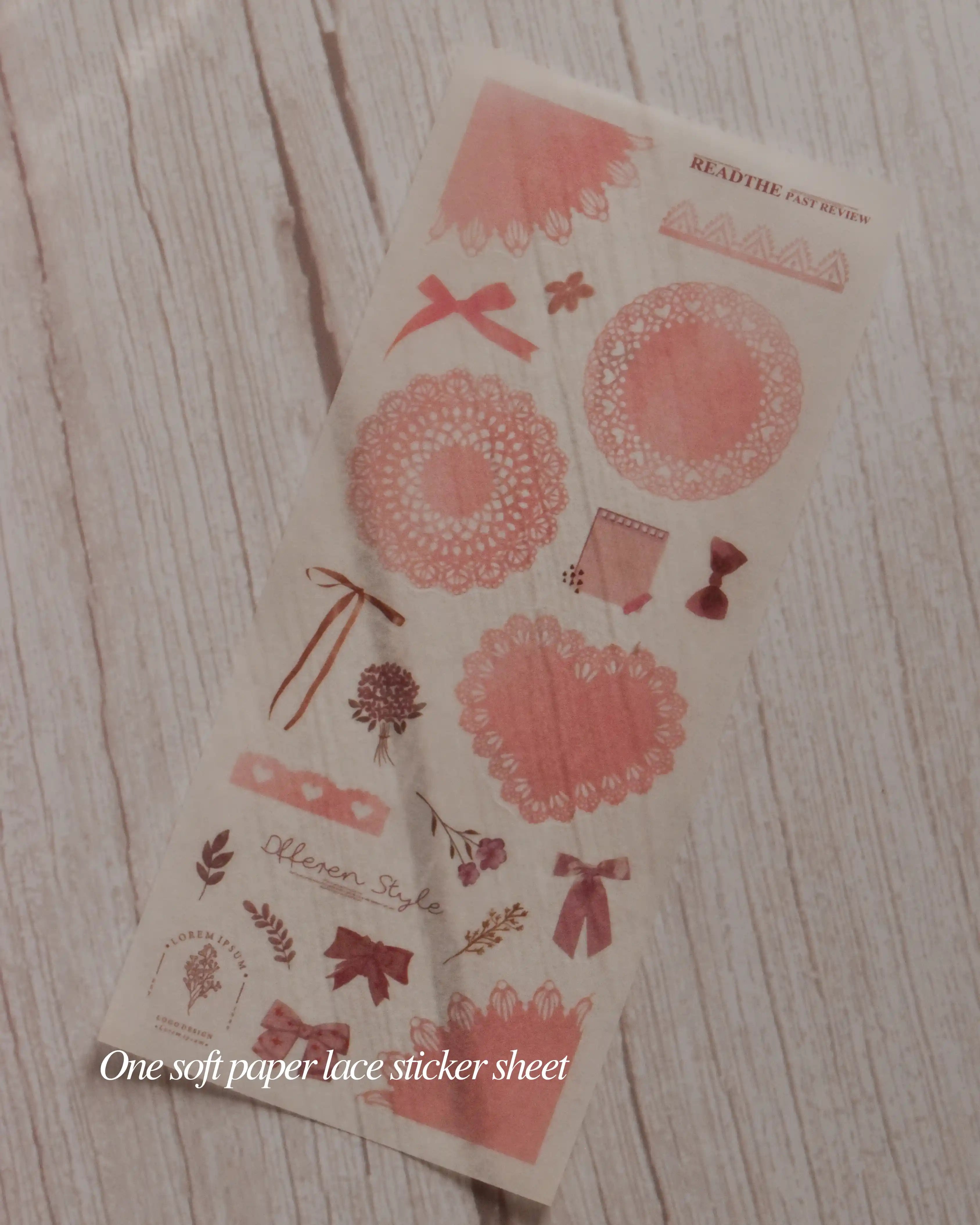Decorative paper lace sticker sheet with floral and bow designs on a wooden surface.