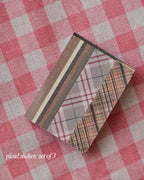 Stack of three plaid patterned stickers in brown, grey, and cream tones, ready for decorative use.