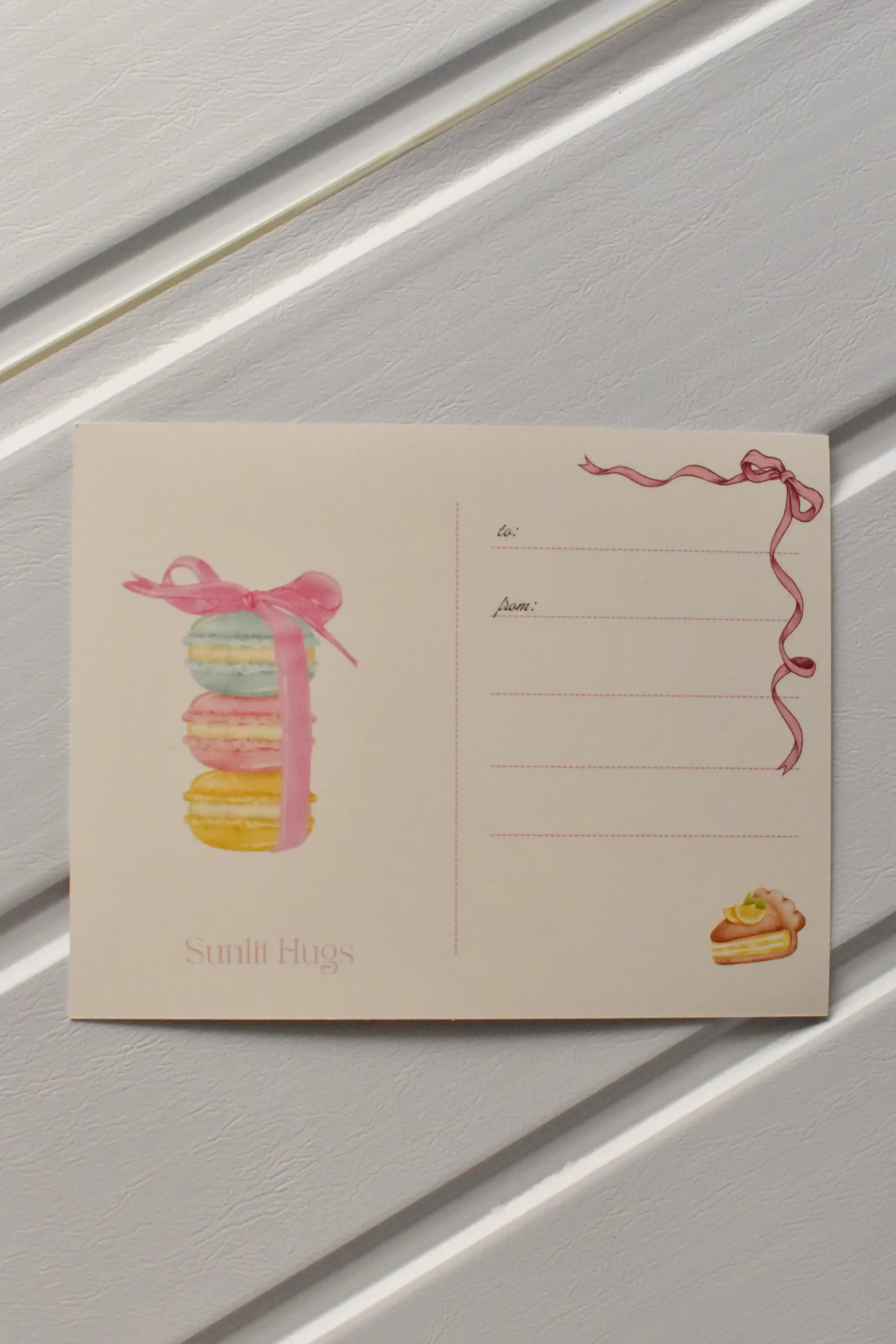 This image focuses on the reverse of the postcard, highlighting the beautiful macaron stack illustration that adds a final touch of sweetness before the postcard is sent.
