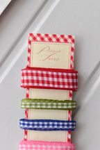 Four narrow gingham ribbons in red, green, blue, and pink, highlighting the textured weave on the 'Picnic Laces' card.