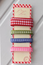 Four narrow gingham ribbons in red, green, blue, and pink, displayed vertically on a themed ribbon card.