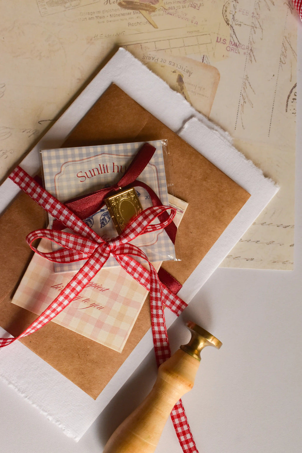 Vintage-inspired birthday gift set with a customised photo pendant, letter, postcards, and birthday card arranged with ribbon and wax seals.
