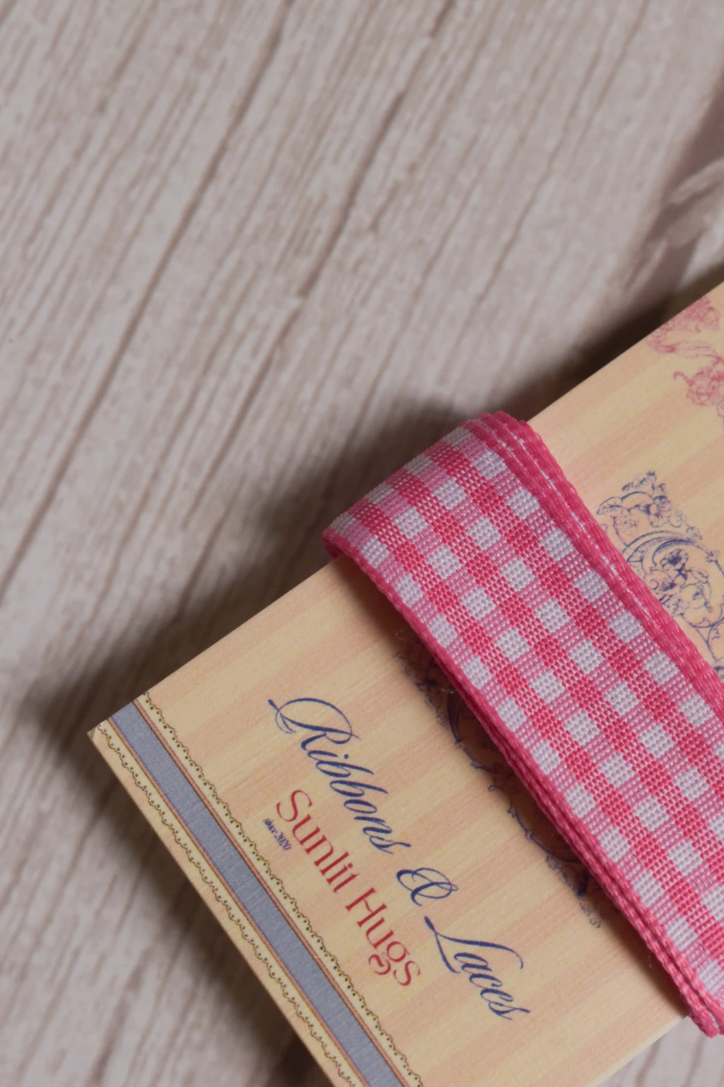 Close-up of Rose Picnic Ribbon wrapped around a printed Sunlit Hugs ribbon card, highlighting its rose pink and white checked pattern and 16 mm width.