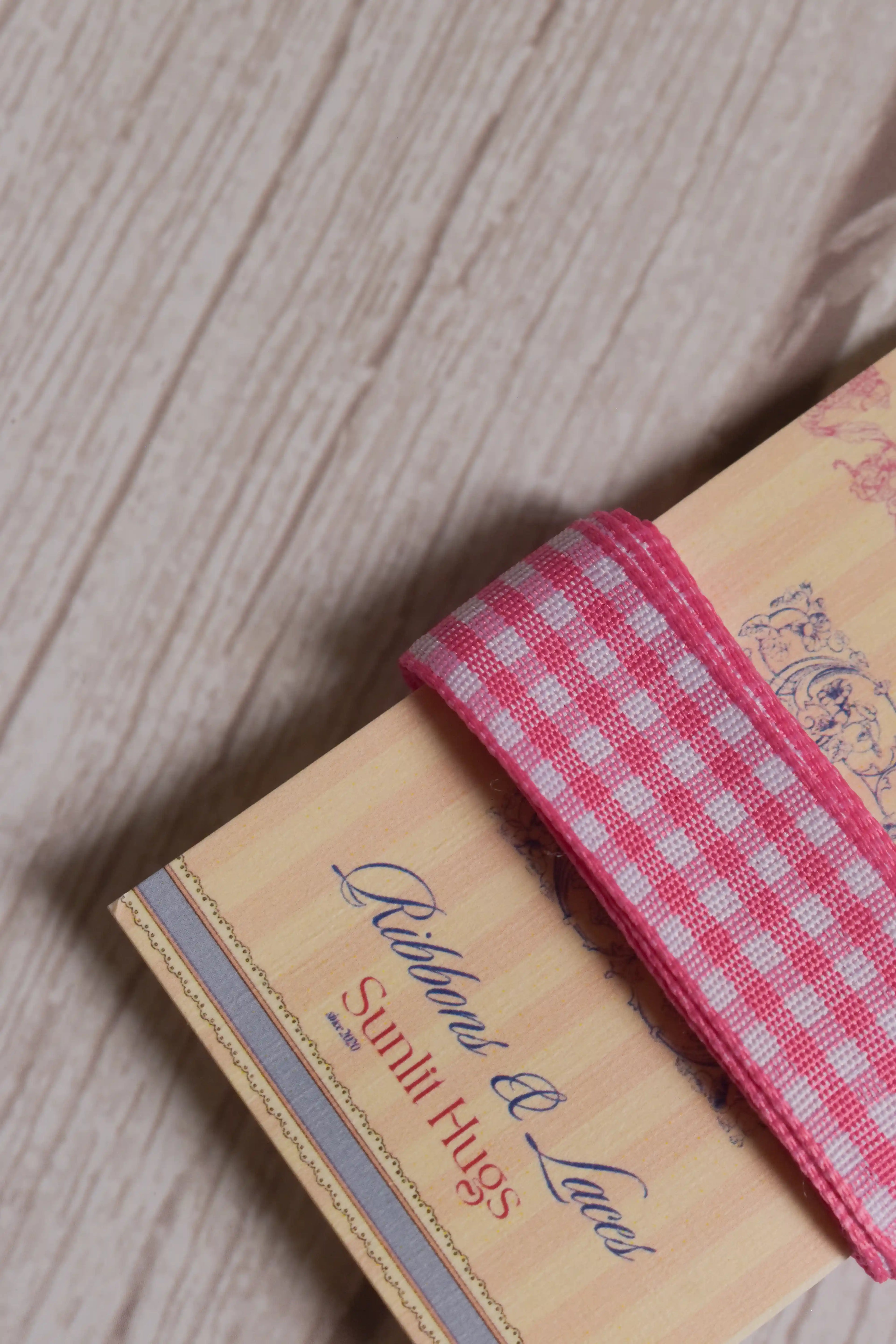 Close-up of Rose Picnic Ribbon wrapped around a printed Sunlit Hugs ribbon card, highlighting its rose pink and white checked pattern and 16 mm width.