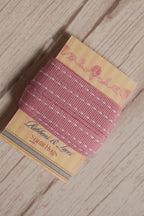 Close-up of Rosette Stitches Ribbon displayed on a Sunlit Hugs ribbon card, showing its soft pink colour and white stitch-style detailing.