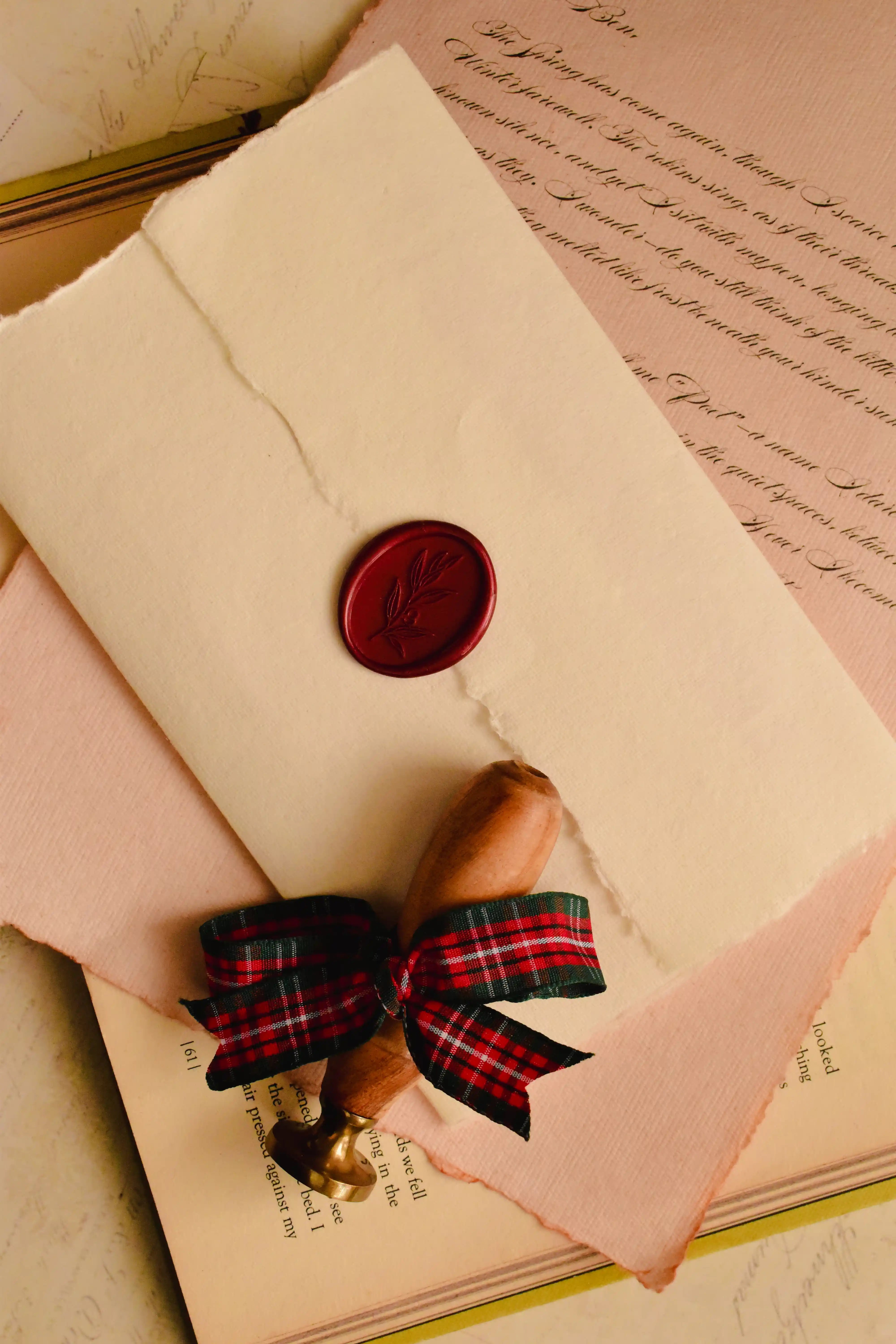 Gummed envelopes stacked with a scarlet wax seal on the top envelope